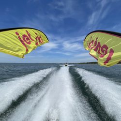 Wasaga Watersports - Jet skis following a boat with jet ski rentals flags.