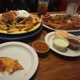 Loaded nachos and appetizer sample platter with chicken tenders, mozzarella sticks, and sweet potato waffle fries Loaded nachos and appetizer sample platter with chicken tenders, mozzarella sticks, and sweet potato waffle fries