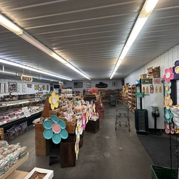 Country Market - A grocery store interior with shelves stocked with various products, shopping carts, and decorative flower cutouts on the walls and door. - Meat Shops Near Me - Springfield, Illinois