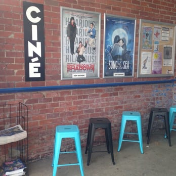Ciné - a row of blue stools in front of a brick wall - Cinema Near Me - Athens, Georgia