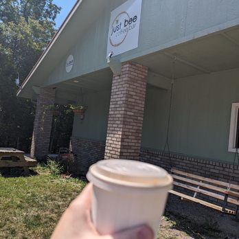 Just Bee Coffee Bar - a hand holding a cup of coffee - Coffee & Tea Near Me - Eureka Springs, Arkansas