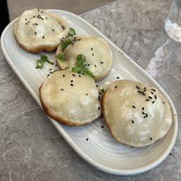 Pan-fried pork buns. Not juicy and slightly burnt underneath. Pan-fried pork buns. Not juicy and slightly burnt underneath.