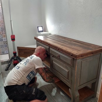 Mister Fixxit Home Repairs - Scott Lunetta works on melding the new vanity with the plumbing for the sink. - General Contractors Near Me Mister Fixxit Home Repairs - Scott Lunetta works on melding the new vanity with the plumbing for the sink. - General Contractors Near Me