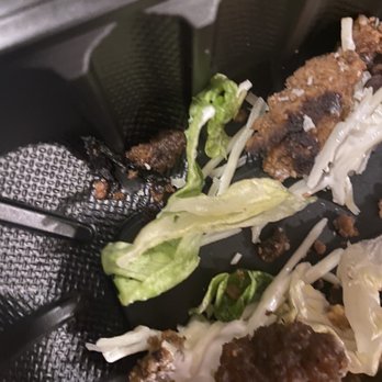Bubbakoo's Burritos - Leftover food on a black plastic tray includes lettuce, shredded cheese, and pieces of cooked meat, with some food remnants scattered around. - Mexican Near Me - Mount Olive, New Jersey