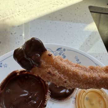 Napoles Churros - Up Close--churro dipped in chocolate sauce. - Desserts Near Me - Fresno, California
