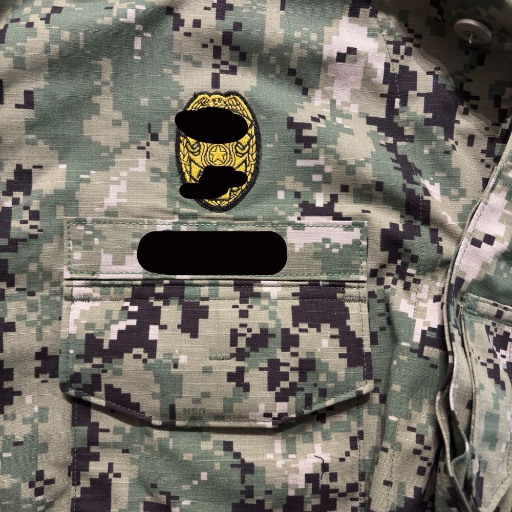 Military Uniform with patches for both the badge and name tag sewn on correctly. Military Uniform with patches for both the badge and name tag sewn on correctly.