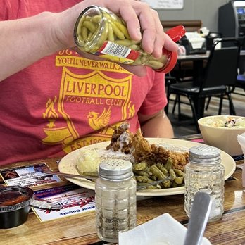 Wagon Wheel Restaurant - a man pouring mustard over a plate of food - Coffee & Tea Near Me - Greenbrier, Arkansas
