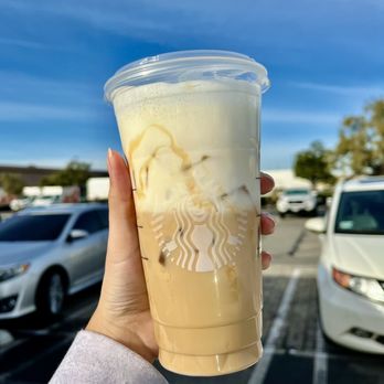 Starbucks - a hand holding a cup of iced coffee - Coffee & Tea Near Me - San Dimas, California Starbucks - a hand holding a cup of iced coffee - Coffee & Tea Near Me - San Dimas, California