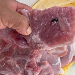 a person holding a piece of meat a person holding a piece of meat