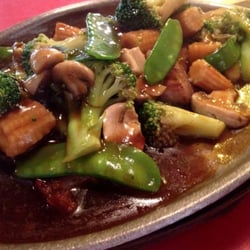 Sizzling steak served on a hot plate. Steak with broccoli, mushrooms, pea pods, and water chestnuts.