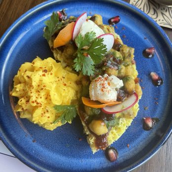 Tamashaa - Ghevar chaat - A dish featuring mashed potatoes with a yellow hue, served alongside a vegetable curry garnished with radish, cilantro, and pomegranate seeds, on a blue ceramic plate. - Indian Near Me - Washington, DC, District of Columbia