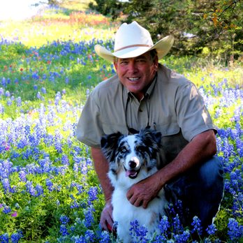 Outdoor Designs - a man kneeling in a field with a dog - Landscaping Near Me - Hutto, Texas Outdoor Designs - a man kneeling in a field with a dog - Landscaping Near Me - Hutto, Texas