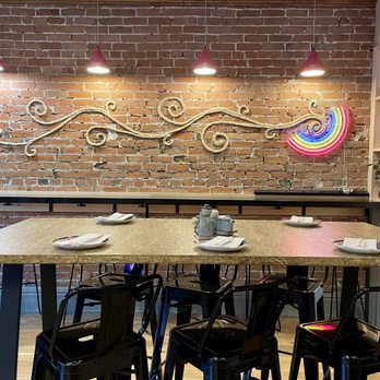 MsSo - Bar seating along the brick wall with a cool neon sign and a large table for a group that can double as communal seating! - Asian Fusion Near Me - Montrose, Colorado
