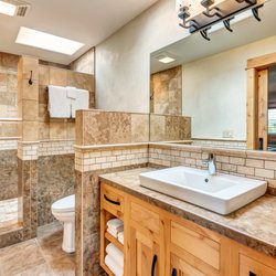 Wall Street Suites - Mt. Bachelor Suite bathroom with walk-in shower and unique custom woodwork and stone tile.