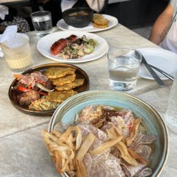 Pictured: zannana cocktail, gratin de lambi, confit de truite, griot, and ceviche