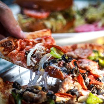 Mary's Pizza Shack - a person taking a slice of pizza - Pizza Near Me - Vacaville, California Mary's Pizza Shack - a person taking a slice of pizza - Pizza Near Me - Vacaville, California
