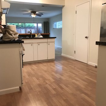 Floors To Go - a kitchen with white cabinets and wood floors - Flooring Near Me - San Jose, California