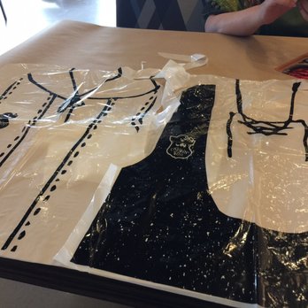 The Captain's Boil - a man sitting at a table with two shirts wrapped in plastic - Cajun/Creole Near Me - Oakville, Ontario The Captain's Boil - a man sitting at a table with two shirts wrapped in plastic - Cajun/Creole Near Me - Oakville, Ontario
