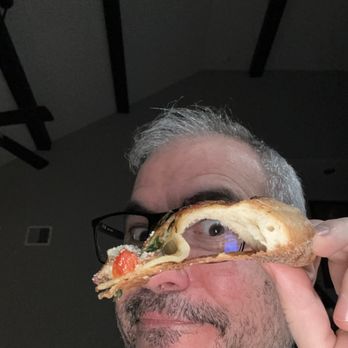 Marco's Pizza - a man holding a slice of pizza - Chicken Wings Near Me - Brookshire, Texas Marco's Pizza - a man holding a slice of pizza - Chicken Wings Near Me - Brookshire, Texas