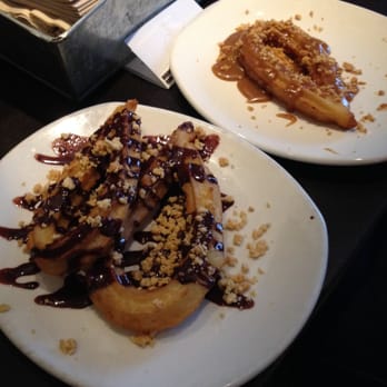 Xoco - Chocolate-peanut glazed churro in the foreground, hazelnut glazed churro in the background. - Mexican Near Me - Chicago, Illinois