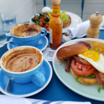 Bluestone Lane - Steiner St Café - a blue table with plates of food and a cup of coffee - Coffee & Tea Near Me - San Francisco, California