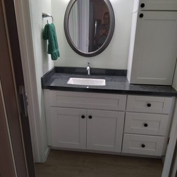 West Coast Construction - a bathroom with a sink and mirror - General Contractors Near Me
