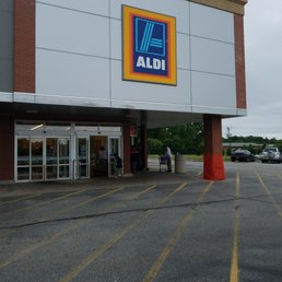 the front of a store with a parking lot in front of it