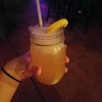 Rhythm & Brews - a person holding a drink in a mason jar - Bars Near Me - Tuscaloosa, Alabama