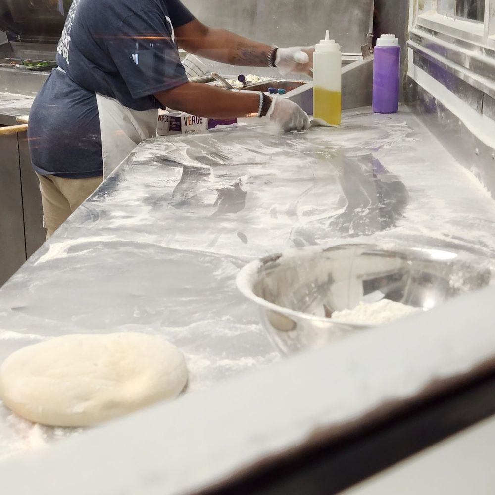 a woman making pizzas in a kitchen