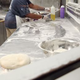 a woman making pizzas in a kitchen