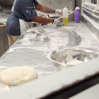 Dewey's Pizza - a woman making pizzas in a kitchen - Pizza Near Me - Cincinnati, Ohio