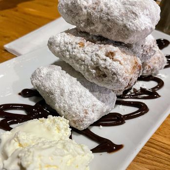 Sweet Breads - a pile of powdered sugared doughnuts on a white plate - New American Near Me - Demorest, Georgia