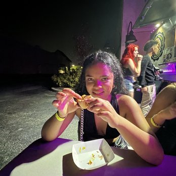 Pav Boti & Juice - a woman eating a slice of pizza - New American Near Me - Orlando, Florida Pav Boti & Juice - a woman eating a slice of pizza - New American Near Me - Orlando, Florida