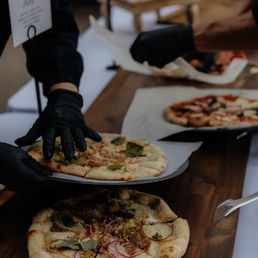 a waiter serving pizzas