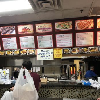 Charcoal Flame Grill - A counter and kitchen view. Greg, the guy in blue, is an active owner. - Greek Near Me - Morton Grove, Illinois Charcoal Flame Grill - A counter and kitchen view. Greg, the guy in blue, is an active owner. - Greek Near Me - Morton Grove, Illinois