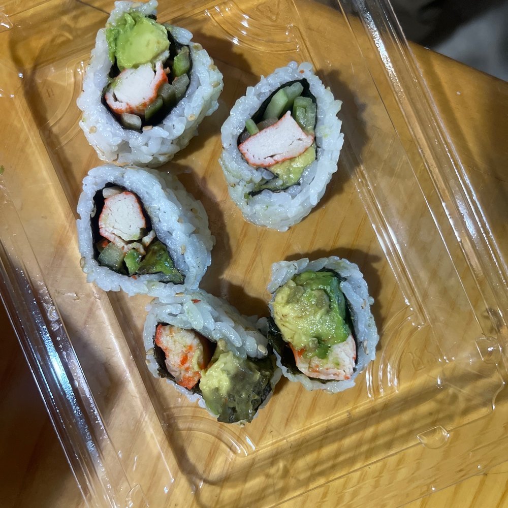 four sushi rolls in a plastic container
