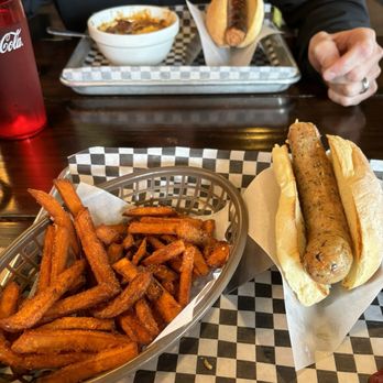 Bangers & Brews Eugene - Chicken Basil with really good sweet potato fries, in the back chili and brisket dog - German Near Me - Eugene, Oregon