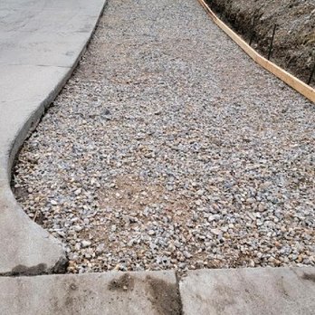 Rusty Wood Construction - a gravel driveway with a tractor in the background - Tree Services Near Me Rusty Wood Construction - a gravel driveway with a tractor in the background - Tree Services Near Me