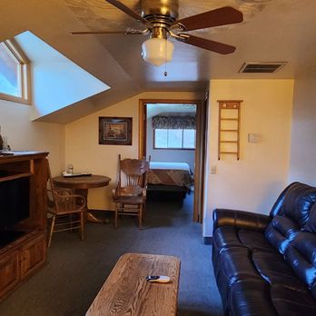 Whispering Pines Lodge - Good sized living room with a small dining table and fireplace - Hotels Near Me - Kernville, California