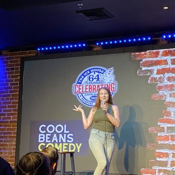 Cool Beans Comedy - A female comedian stands on stage at Cool Beans Comedy in Pasadena, holding a microphone and engaging the audience during a performance. - Performing Arts Near Me - Pasadena, California