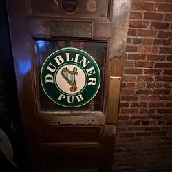 Dubliner Pub - Door with a green circular decal labelled "DUBLINER PUB"