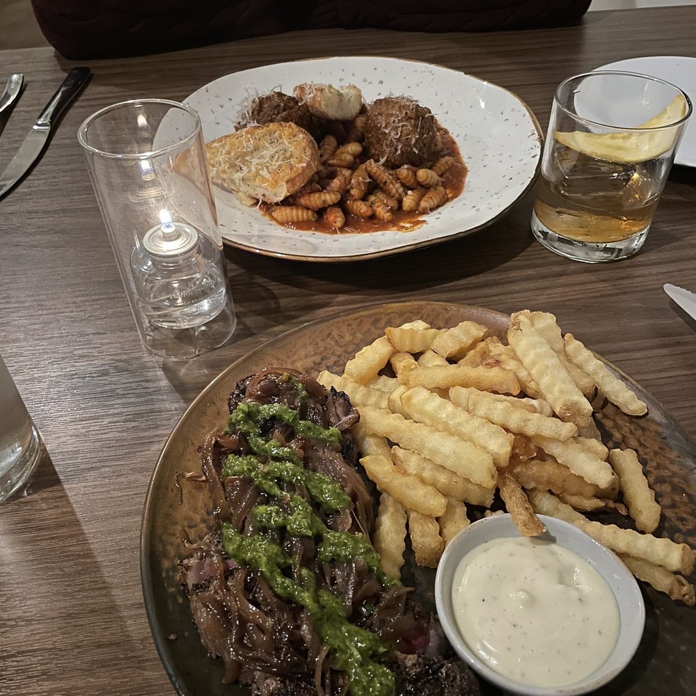 Aftermath Kitchen & Bar - Steak frites and meatball gnocchi in the background - New American Near Me - Phoenix, Arizona Aftermath Kitchen & Bar - Steak frites and meatball gnocchi in the background - New American Near Me - Phoenix, Arizona
