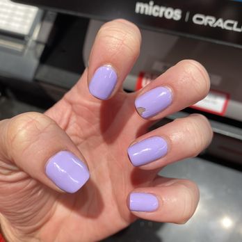 Bella Nail Spa - 2 days after NO CHIP POLISH and it's already chipping .. - A person's hand with lavender-colored nail polish, which is chipped and worn on several nails, is held in front of a computer screen. - Nail Salons Near Me - Aurora, Illinois