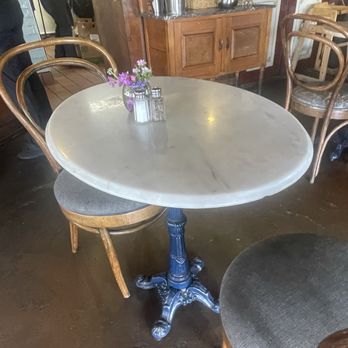 Cafe Madeleine - Cute cafe chairs and blue metal based tables add to French charm - Cafes Near Me - San Diego, California