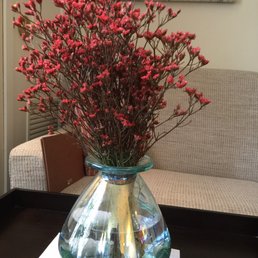 a vase of red flowers on a table