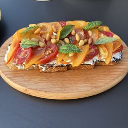 Heirloom Tomato Toast: grilled sourdough, fresh goat cheese, peaches, pin nuts, and mint Heirloom Tomato Toast: grilled sourdough, fresh goat cheese, peaches, pin nuts, and mint