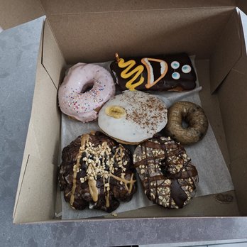 Voodoo Doughnut - The Homer, Voodoo Dool, Banana Cream Pie, Blueberry Cake, Memphis Mafia & Chuckles. - Donuts Near Me - Tempe, Arizona Voodoo Doughnut - The Homer, Voodoo Dool, Banana Cream Pie, Blueberry Cake, Memphis Mafia & Chuckles. - Donuts Near Me - Tempe, Arizona