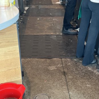 Starbucks - The image shows a store checkout counter with customers waiting in line, and a red mop bucket on the wet floor. - Coffee & Tea Near Me - Clearlake, California
