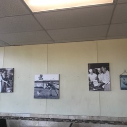 a wall with pictures of people in a restaurant