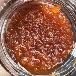 a hand holding a jar of jam a hand holding a jar of jam